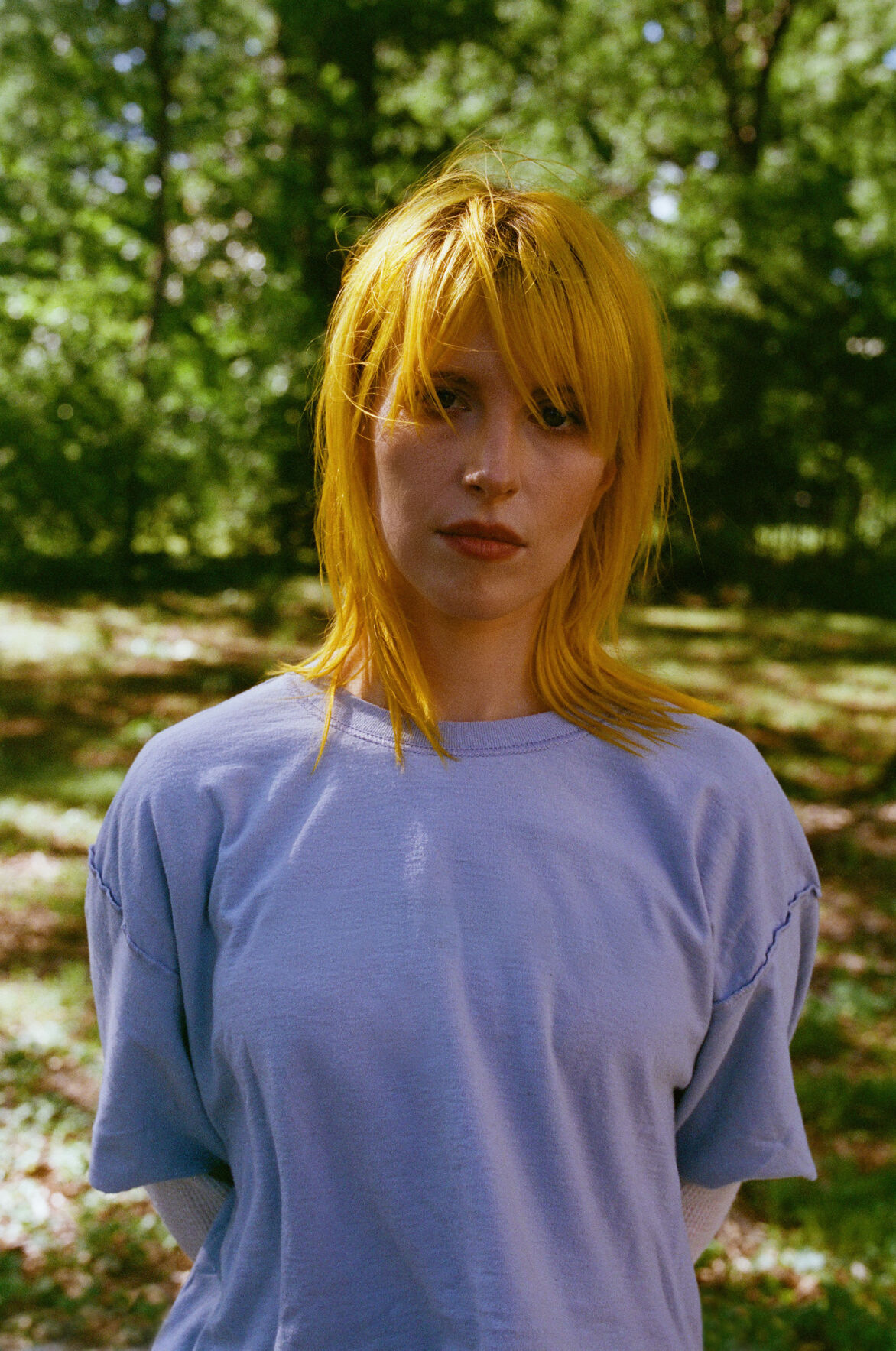 Hayley Williams press pic 2025 artist stands in the woods wearing a gray T-shirt